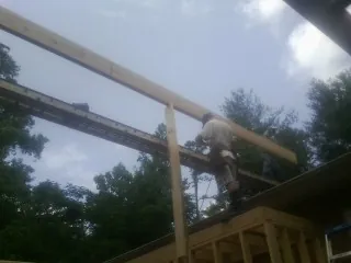 Carpenter setting a ridge beam over a new addition frame — Ice Dam Removal by Roofing Brothers in Hortonville