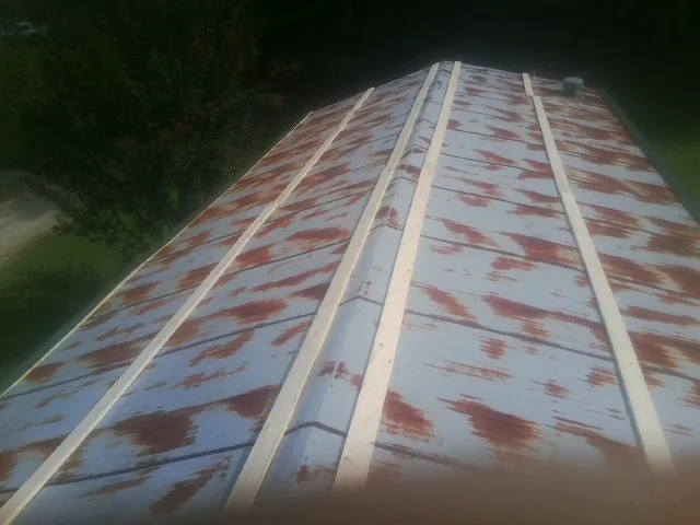 Rusted metal roof panels with new wood purlins before replacement — Storm Damage Roof Repair in Hortonville by Roofing Brothers
