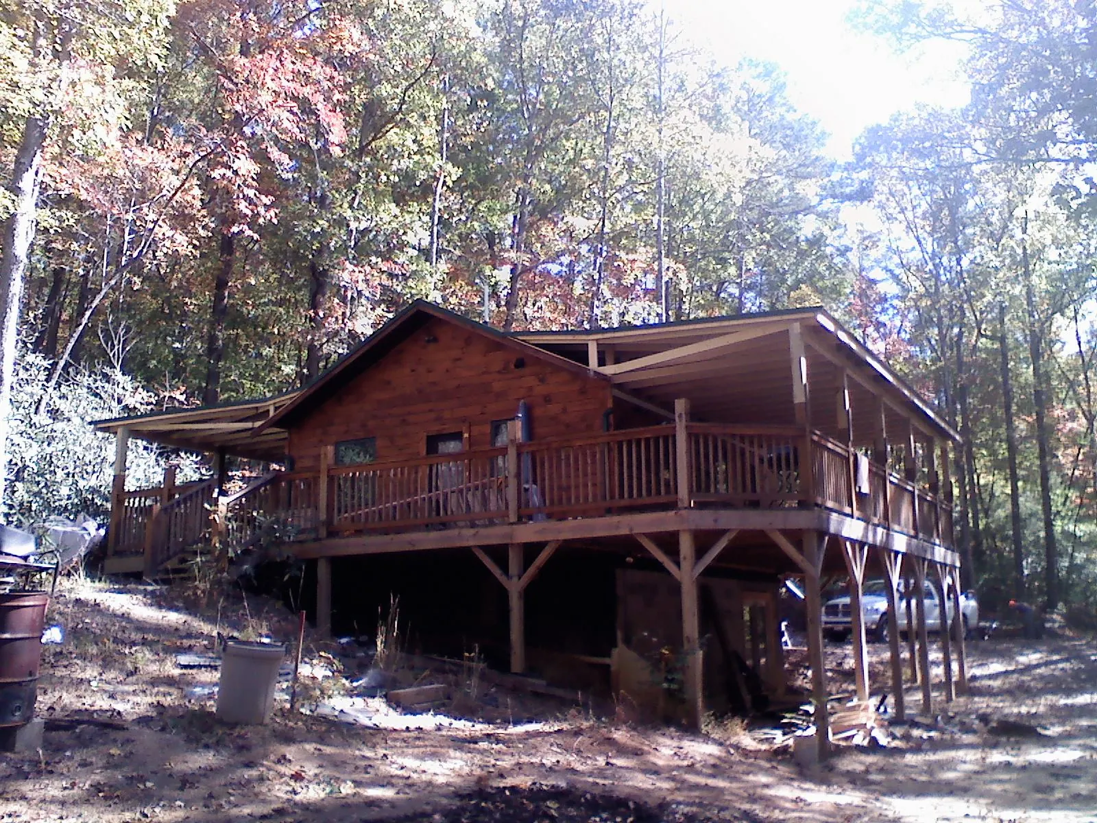 Log cabin with a wraparound porch and metal roof in the fall in Hortonville