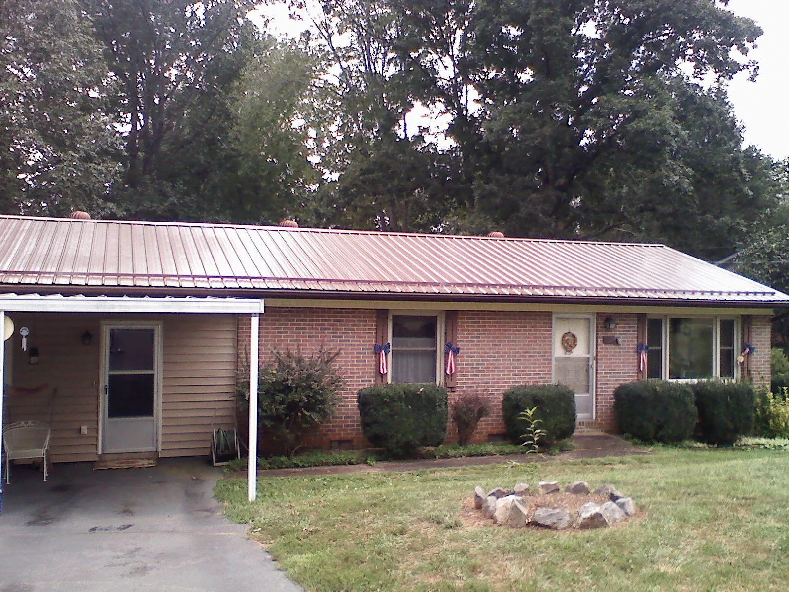 Bronze metal roof and carport on a brick ranch home — Roof Repair work by our crew in Hortonville